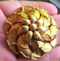 Front view of gold-tone floral brooch showing layered petals