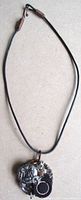 Full view of necklace showing black cord and pendant