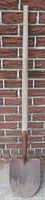Full view of shovel against brick wall