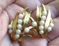 Front view of earrings showing faux pearl clusters and gold-tone leaf design