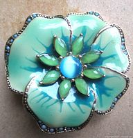 Front view of brooch showing enamel petals and cabochon center