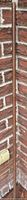 Full view of metal tube leaning against brick wall