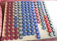Wide view of entire arranged collection of beer caps on board