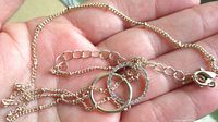 Close view of chain, interlocking rings pendant, lobster clasp and extender