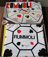 Box top and folded play sheet displaying Rummoli graphics