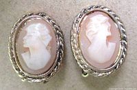 Front view of both cameo earrings showing carved profiles and gold-tone frames
