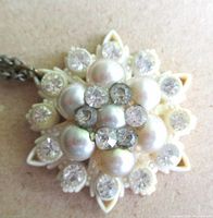 Close-up of pendant showing faux pearls, rhinestones, snowflake floral design