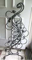 Front view of wrought iron scroll wine rack showing full height and design