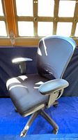 Front-angled view of the black mesh office chair showing mesh back, fabric seat and armrests