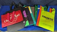 Assorted branded tote bags spread out showing fronts