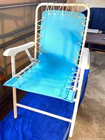 Front view of one blue-teal sling chair showing frame, laced sides, armrests