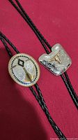 Front view of both bolo tie slides on cords