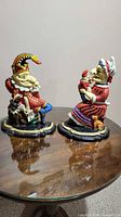Front view of both Punch and Judy cast iron door stops on table