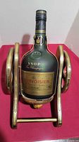 Front view of sealed Courvoisier VSOP bottle in cannon stand