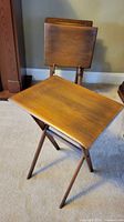 One walnut folding side table open with others folded behind
