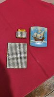 All three items: rhinestone cigarette case, matching lighter, blue enamel case