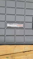 WeatherTech logo close-up on cargo liner grid surface