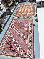 Two kilim rugs laid out showing full patterns and fringe
