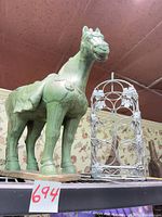 Horse statue and wine rack side by side on shelf