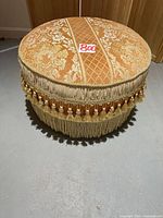 Ottoman side perspective showing fabric and fringe