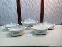 Front view of all five casserole dishes and four lids