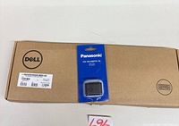 Sealed Dell keyboard box alongside Panasonic battery pack on top