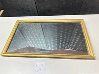 Front view of mirror showing gold frame and glass