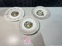 Three decorative dinner plates laid out showing fronts and patterns
