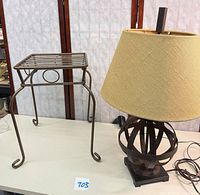 Lamp and plant stand together on tabletop