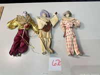 Group shot of three porcelain-head harlequin/clown dolls