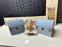 Two blue wooden chests, rag doll, partial view of both plaques