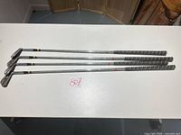 Four MacGregor irons laid flat showing full length