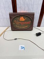 Front view of illuminated Narragansett sign with power cord visible