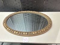 Front view of ornate oval gold gilt mirror