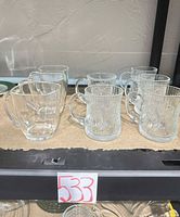 Group shot of all eight glass mugs, two distinct styles visible