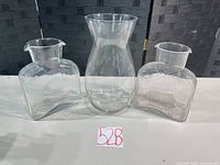 Three clear crackle glass vases displayed side by side