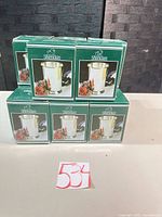 Stacked Sheridan branded green boxes displaying silver-plated tumbler image