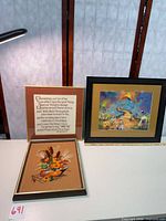 All three framed stitchery pieces on table