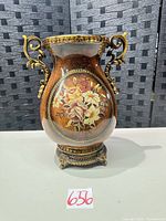 Full view of vase front showing floral panel, handles and base