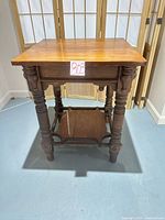 Full view of solid wood side table showing turned legs and lower shelf