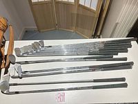 Group of steel-shaft irons and putter laid out