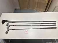 Full view of four clubs laid out showing shafts and grips