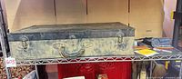 Closed vintage metal toolbox on shelf