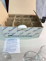 Box containing divided compartments holding twelve glasses