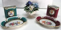 Group shot showing both cigarette holders, both ashtrays, and floral posy