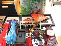 Overview of abacus, parasols, fan, figurines, drum, inkstone, tassel, cup, framed art
