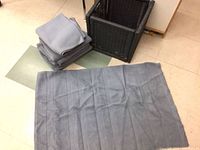 Folded gray ribbed mat on floor with stack and basket visible