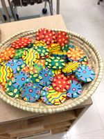 Basket filled with multicolor wooden discs showing patterns and notches
