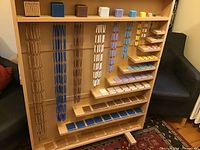 Full view of wooden cabinet loaded with bead cubes, squares and hanging chains