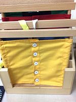 Yellow frame with six white buttons mounted in wooden rack